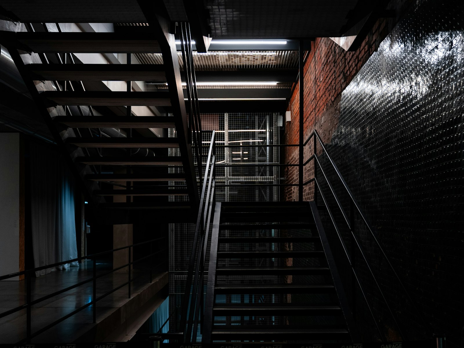 Freitragende Stahltreppe in einem Loft mit Backsteinwand