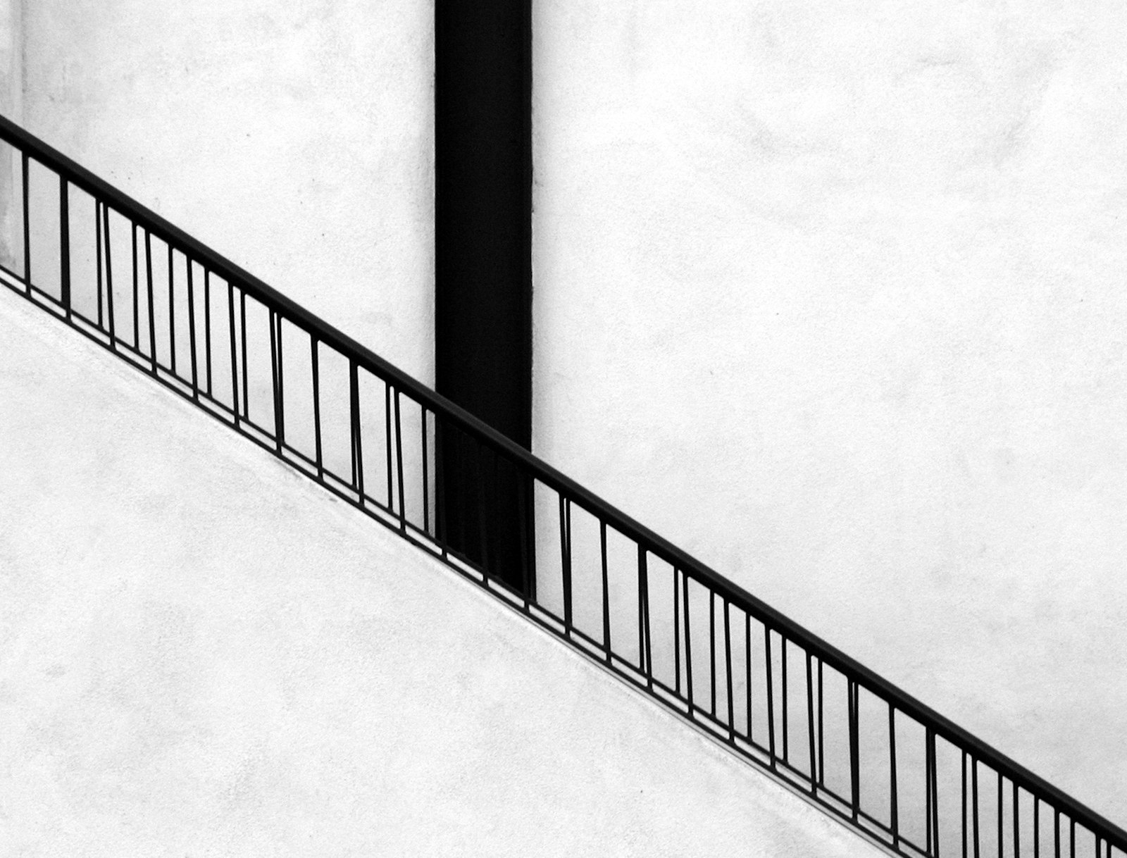 Minimalistisches schwarzes Geländer an einer weißen Wand