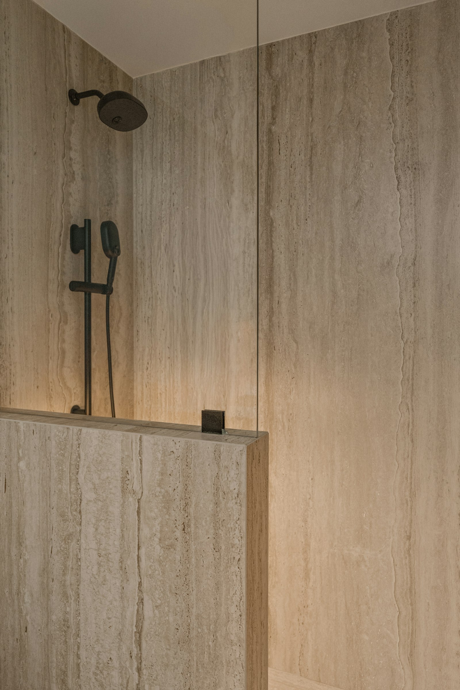 Travertin-Dusche mit warmer Beleuchtung, Detailaufnahme