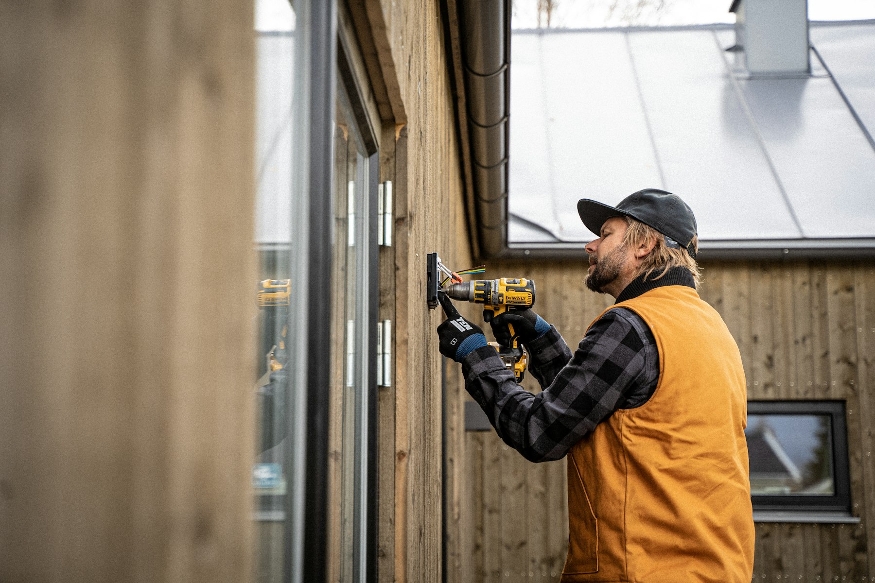 Elektriker bei der Montage an der Hauswand